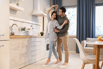 Lovely young interracial couple dancing at home