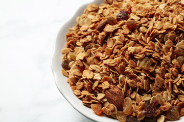 Tasty muesli with raisins on table, closeup. Healthy breakfast