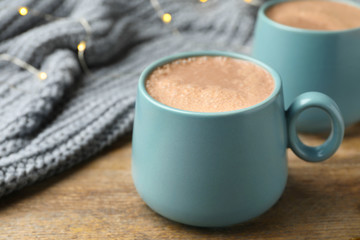 Cups of delicious hot cocoa on wooden table