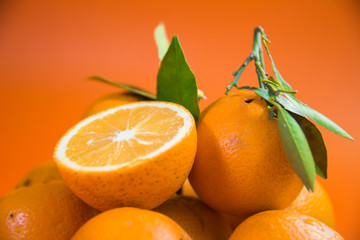 fresh pulpy juicy oranges on vibrant orange background