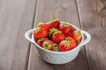 Homemade strawberries in a white plate close-up and copy space.