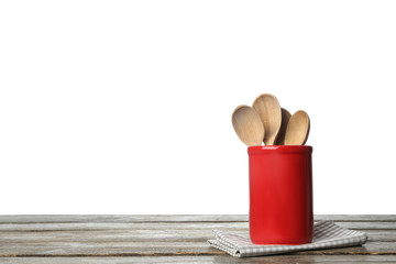 Folded kitchen towel and holder with spoons on wooden table. Space for design