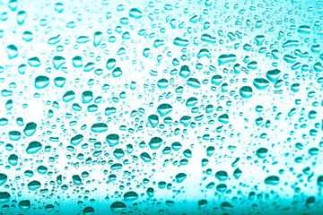 Drops of water on a glass background. Green. Selective focus. Toned