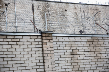 Prison or protected area. High brick walls with barbed wire.