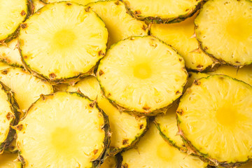 Pineapple juicy yellow slices background. Top view.