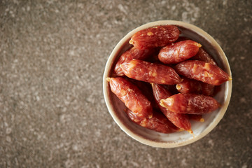 Small salami sausage on stone background 