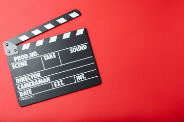 Fototapeta na wymiar Clapper board on red background, top view with space for text. Cinema production