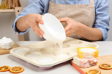 Woman making natural handmade soap at white table, closeup