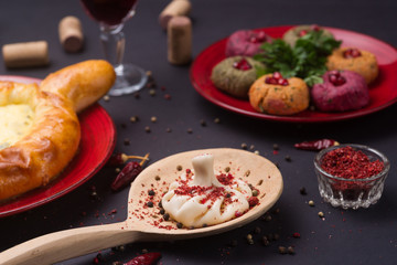 Georgian food on black table. khinkali, phali,  khachapuri with tomatos, adjika and a glass of wine.