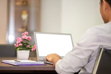 Office workers using laptops on the table with clipping path on white screen. Notebook with white screen on the wooden table in the office building at bangkok , Thailand.