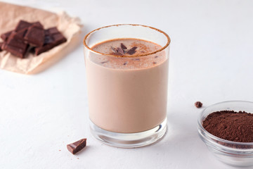 Lassi indian chocolate drink next to chocolate and cocoa on a white background