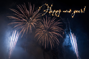 Happy New Year sparkling text with fireworks background. 