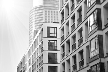 Sun rays light effects on urban buildings. Fragment of modern residential apartment with flat buildings exterior. Detail of new luxury house and home complex. Black and white.