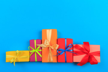 Different colored gift box on color background. Top view of various present boxes on minimal...
