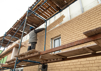 Naklejka premium Installation of siding on the walls of the house