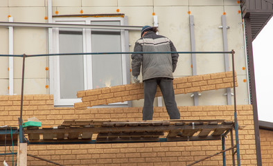Installation of siding on the walls of the house
