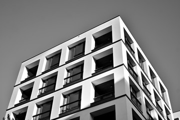 Sun rays light effects on urban buildings. Fragment of modern residential apartment with flat buildings exterior. Detail of new luxury house and home complex. Black and white.