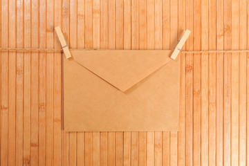 Old paper envelope hanging on rope on wooden background - Image