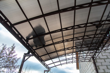 A worker mounts a metal canopy in the courtyard of the house