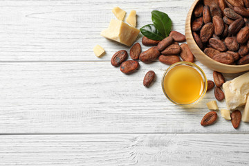 Flat lay composition with organic cocoa butter on white wooden table. Space for text