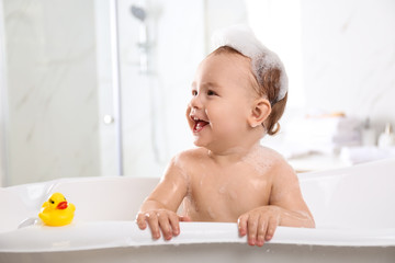 Cute little baby in bathtub at home