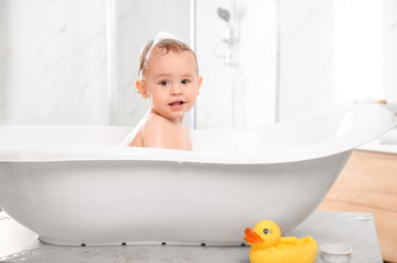 Cute little baby in bathtub at home