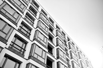 Sun rays light effects on urban buildings. Fragment of modern residential apartment with flat buildings exterior. Detail of new luxury house and home complex. Black and white.