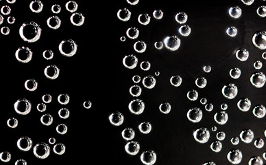Air balls in water on a black background