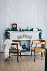 Festive interior: armchair, fireplace, Christmas clock and Christmas toys. The concept of Christmas and the New year. Boce as background