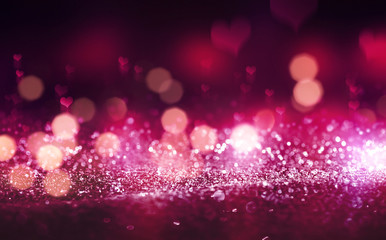 Hearts on a sparkling shiny background. Red abstract background. Blurry bokeh, neon light.