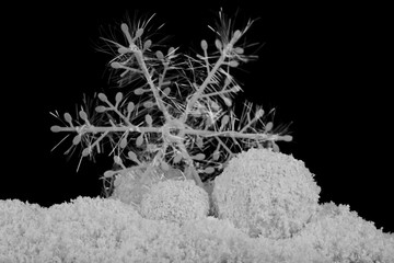 A pile, a snowdrift of white fluffy snow and a snowflake isolated on a black background