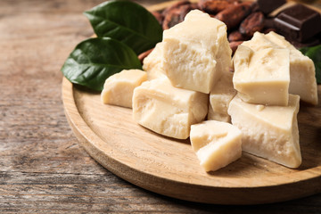 Organic cocoa butter on wooden table, closeup