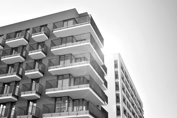 Sun rays light effects on urban buildings. Fragment of modern residential apartment with flat buildings exterior. Detail of new luxury house and home complex. Black and white.