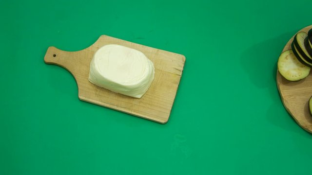 stop motion time lapse of the preparation of eggplant parmigiana on a green background