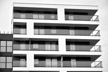 Sun rays light effects on urban buildings. Fragment of modern residential apartment with flat buildings exterior. Detail of new luxury house and home complex. Black and white.