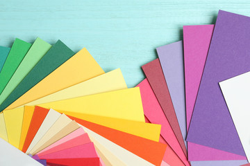 Color palettes on light blue wooden background, flat lay