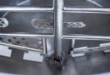 Stainless tank with stirrer for food production.