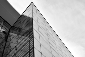 Sun rays light effects on urban buildings in sunset. Modern office building detail, glass surface with sunlight. Business background. Black and white.