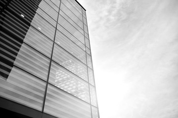 Sun rays light effects on urban buildings in sunset. Modern office building detail, glass surface with sunlight. Business background. Black and white.