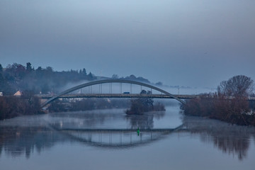Morgennebel um eine Brücke am Fluss