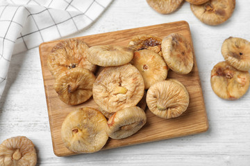 Tasty dried figs on white wooden table, flat lay