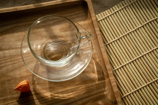 Still life with a cup  with transparent material and a ripe fesalis flower.