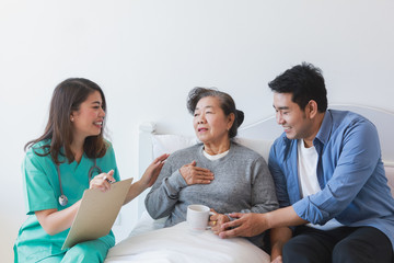 Asian Senior old woman on the bed with doctor and her son in hospital - Powered by Adobe