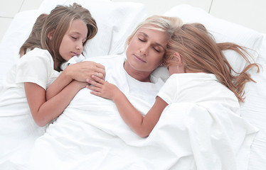 happy mother with her daughters are fast asleep together