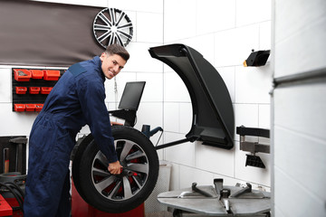 Obraz na płótnie Canvas Man near wheel balancing machine at tire service