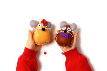 Sewing mouse toys from felt on children's hands.