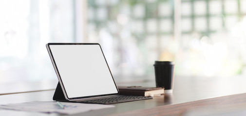 Close-up view of modern office room with blank screen tablet and office supplies