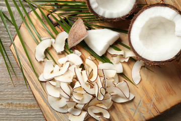 Composition with tasty coconut chips on wooden table, above view