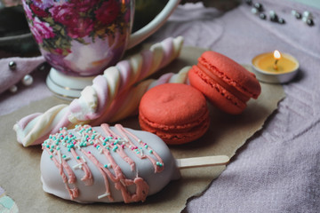 Pink sweets and a cup of tea. Marshmallows, macaroons, cake, ice cream, rose, candle. St. Valentine's Day