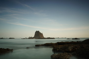 the atmosphere of the beach or the coast before the afternoon with calm waves and sunny weather set against the background of the high seas and mountains or plateaus
